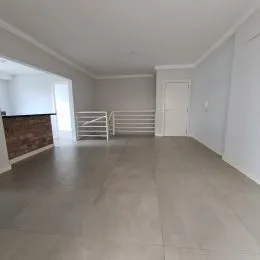 Hall de entrada com piso claro e paredes brancas em um imóvel.
