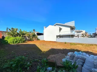 Vista externa de uma residência em Lajeado, Brasil, com um pátio gramado e vegetação.