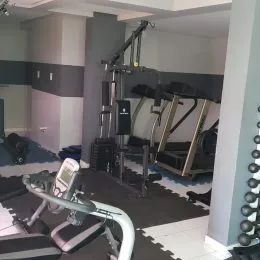 Foto de uma área de ginástica com equipamentos de musculação.
