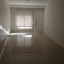Hall de entrada com piso reflexivo e janelas claras.
