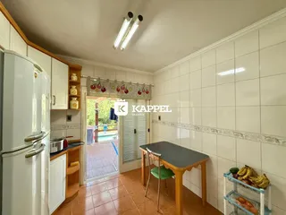 Foto interna de uma cozinha com armários brancos e piso de cerâmica.