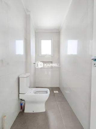 Foto de um banheiro moderno com revestimento branco e piso claro.