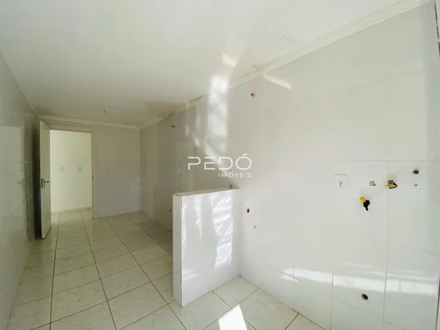 Corredor interno com piso de cerâmica e paredes brancas.