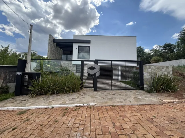 Fachada moderna de uma residência com portão de ferro e jardim na Lajeado.