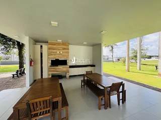 Área externa com mesa de madeira e vista para o jardim.