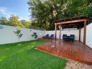 Área externa com deck de madeira e gramado em Lajeado.