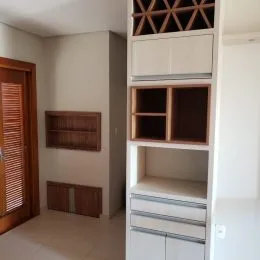 Armários embutidos com prateleiras brancas em um ambiente interno.