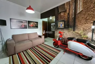 Sala de estar com sofá e tapete em um imóvel.