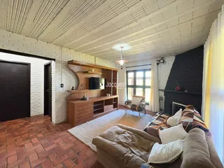 Sala de estar com piso de tijolo e móveis de madeira.