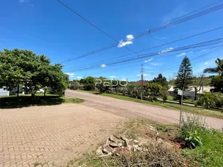 Vista externa de uma propriedade com área gramada e estrada.