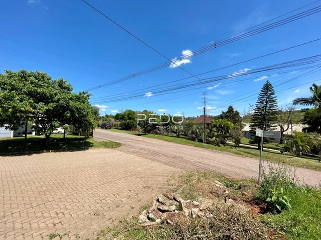 Vista externa de uma propriedade com área gramada e estrada.