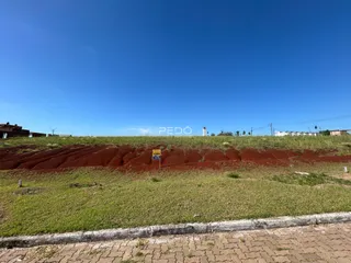 Vista de uma área de terra com grama e céu azul em Lajeado.