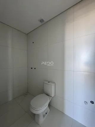 Foto de um banheiro com revestimento cerâmico branco.