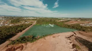 Vista aérea de uma área com corpo d'água cercada por vegetação e terra.