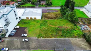 Vista externa de um terreno com gramado e um edifício comercial.