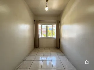 Corredor interno de uma residência com piso de cerâmica claro.