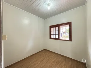 Foto de um cômodo interno com piso de madeira e janela.