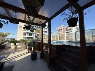 Vista da área de lazer com piscina e jardim de um apartamento em Lajeado.