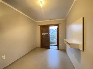 Vista de um corredor interno com paredes claras e piso de cerâmica.