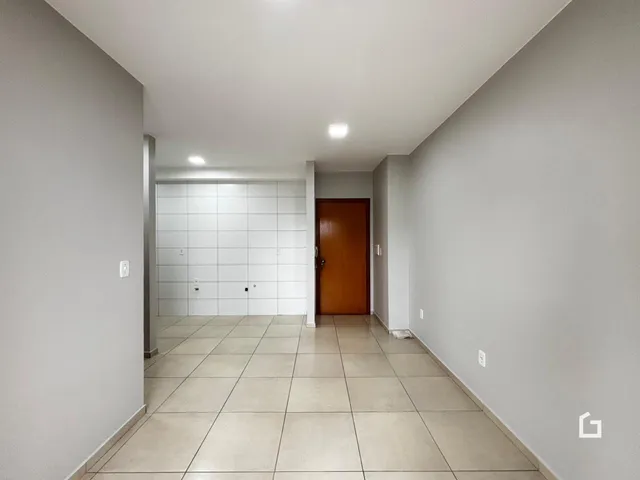 Corredor interno de uma residência com piso de cerâmica clara.