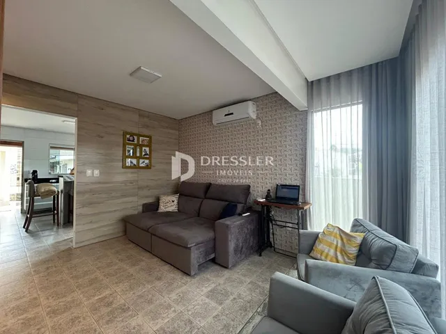 Sala de estar com sofá e piso de cerâmica em um imóvel no Brasil.