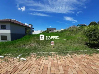 Fachada de uma residência com gramado e paisagem no primeiro plano.