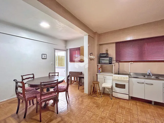 Foto de uma sala de jantar com mesa de madeira em uma residência no Brasil.