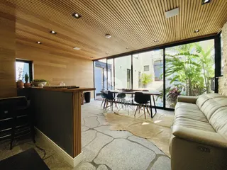 Sala de estar com portas de vidro que dão vista para o jardim externo.