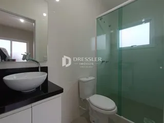 Foto de um banheiro moderno com box de vidro e louças brancas.