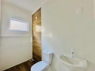 Foto de um banheiro com piso de madeira e azulejos brancos.