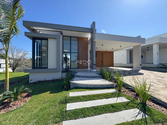 Fachada moderna de uma residência em Lajeado, Brasil, com jardim frontal.