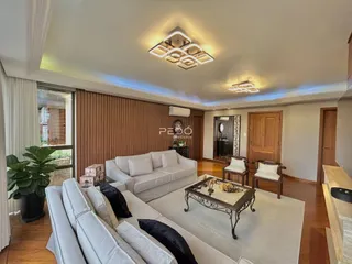 Sala de estar com dois sofás brancos e piso de madeira clara.