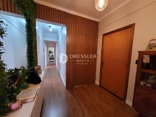 Corredor interno de uma residência com revestimento de madeira.