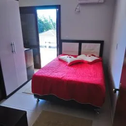 Quarto com cama de casal e paredes brancas.