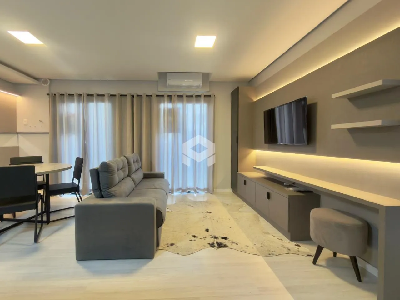 Sala de estar moderna com sofá e iluminação clara.