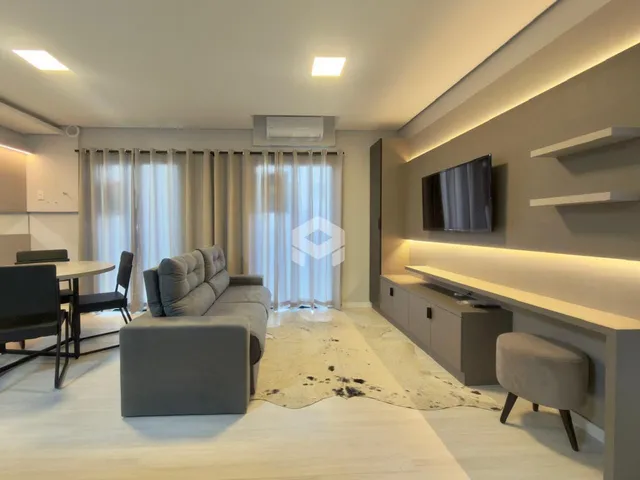 Sala de estar moderna com sofá e iluminação clara.
