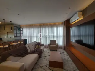 Sala de estar moderna com sofá e televisão em um apartamento.