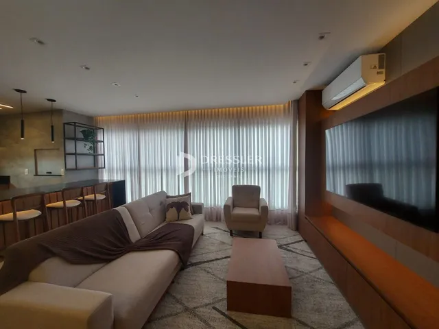 Sala de estar moderna com sofá e televisão em um apartamento.
