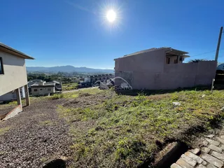 Vista externa da residência em Lajeado, Brasil, mostrando o terreno e a paisagem ao fundo.