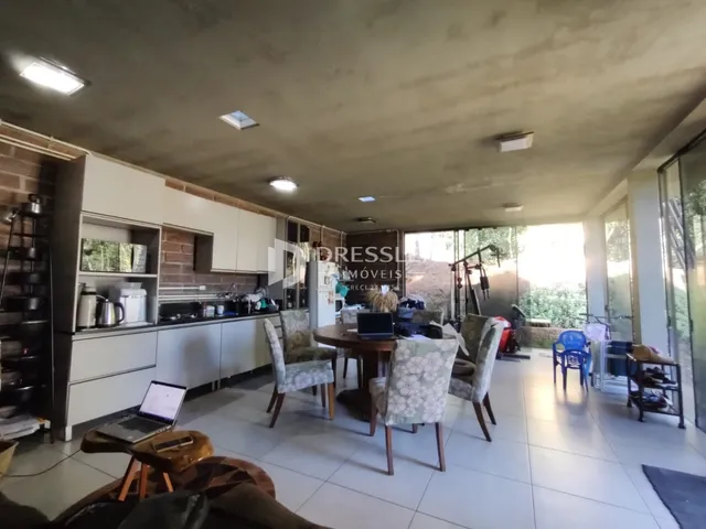 Ambiente interno de uma sala de estar com cozinha aberta e área de jantar.
