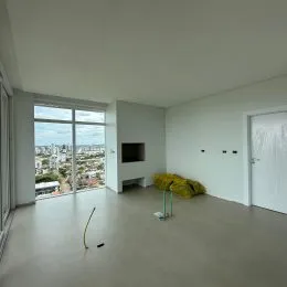 Sala de estar com grandes janelas oferecendo uma vista panorâmica da cidade.