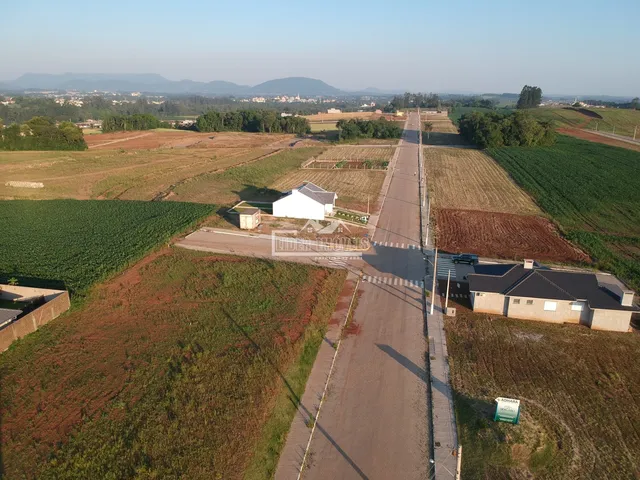 Vista aérea de uma propriedade rural com campos agrícolas e uma estrada.