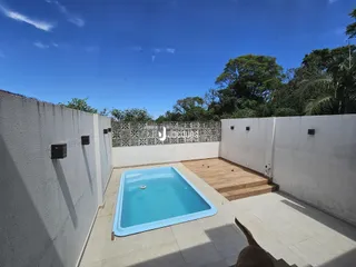 Piscina externa com deck de madeira em um quintal.