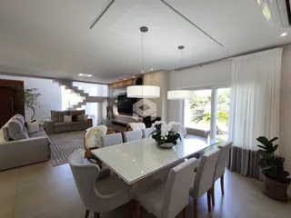 Sala de estar e jantar moderna com grandes janelas e vista para o exterior.