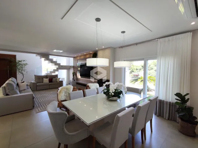 Sala de estar e jantar moderna com grandes janelas e vista para o exterior.