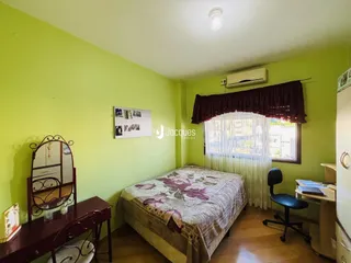 Quarto com cama e janela em uma residência.