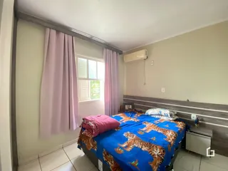 Quarto com janela e cortinas rosa na sala.