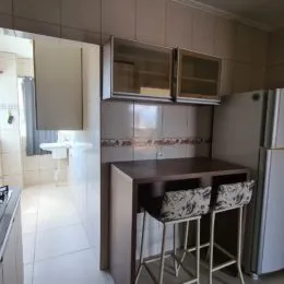 Foto interna de uma cozinha com armários e eletrodomésticos.