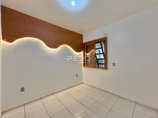 Ambiente interno com parede de madeira e piso cerâmico claro.