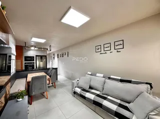 Interior de uma sala de estar com cozinha em um imóvel no Brasil.